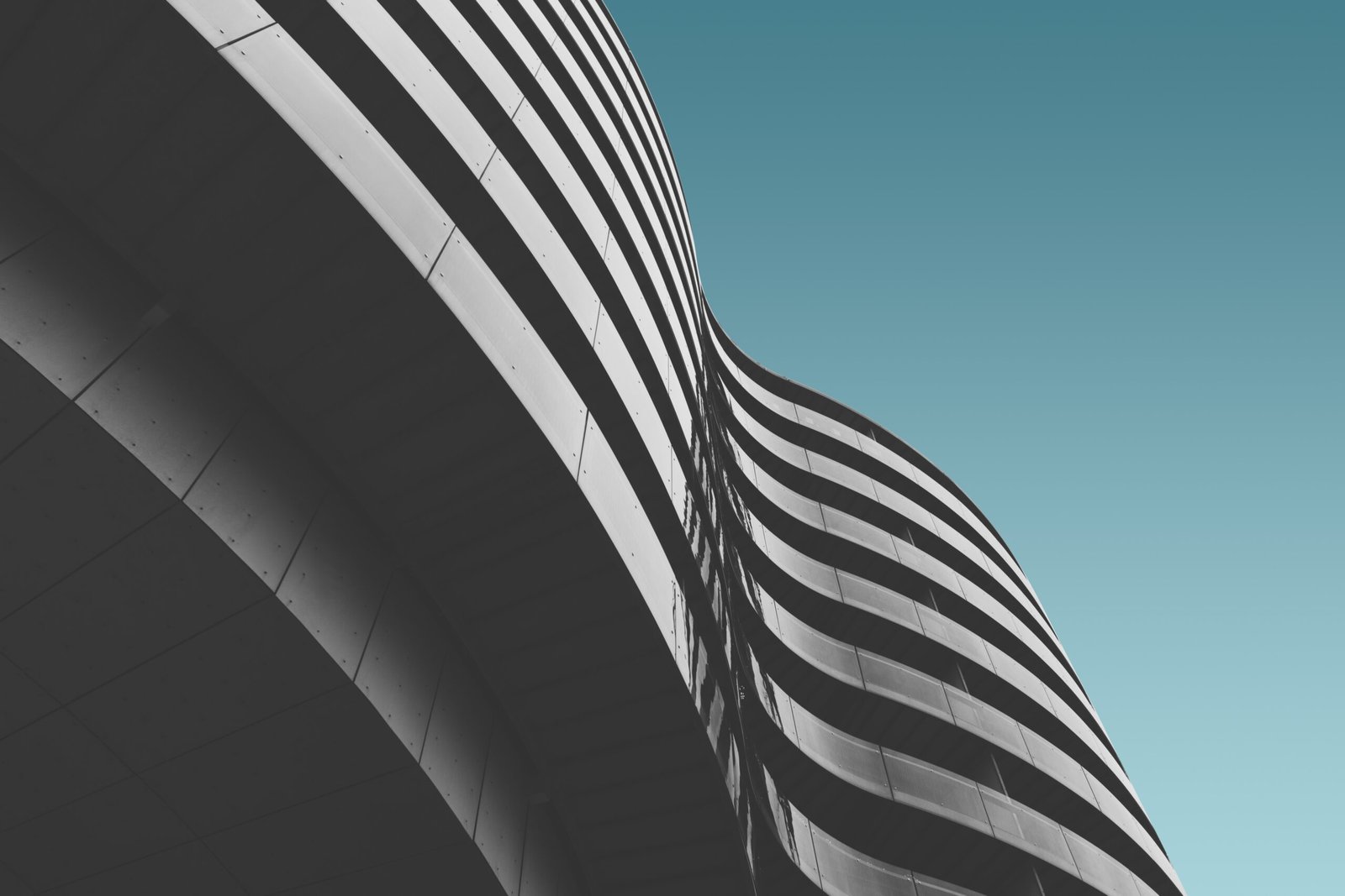 A low angle shot of a grey concrete building under the blue sky